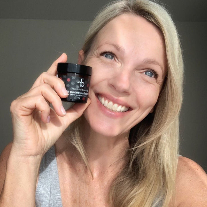 Happy beautiful mature woman holding Kakadu Plum Facial Cream